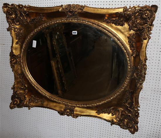 A gilt-framed wall mirror with oval plate